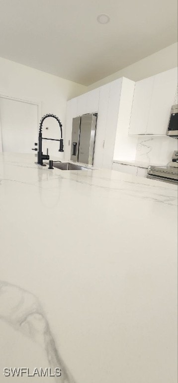 interior space with white cabinets and sink