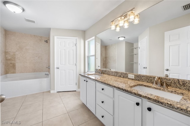 bathroom featuring tile patterned floors, vanity, and tiled shower / bath combo