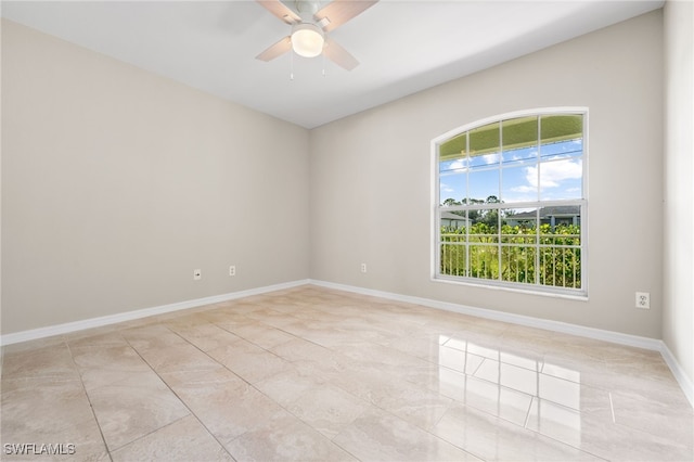 empty room with ceiling fan and light tile patterned floors