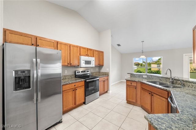 kitchen with lofted ceiling, stainless steel appliances, sink, pendant lighting, and light tile patterned floors