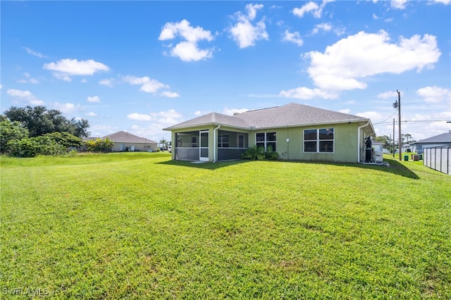 rear view of property with a sunroom and a lawn