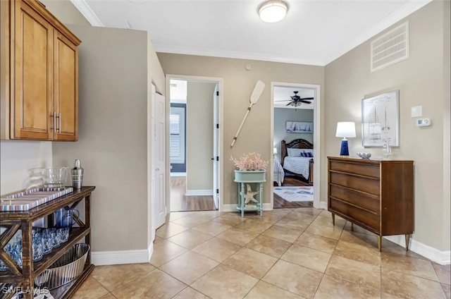 interior space with crown molding and light tile patterned flooring