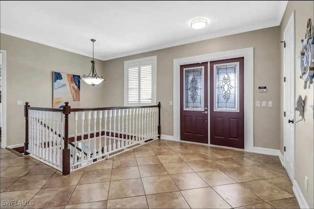 entrance foyer with crown molding and tile patterned floors