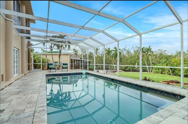 view of swimming pool featuring a patio and glass enclosure