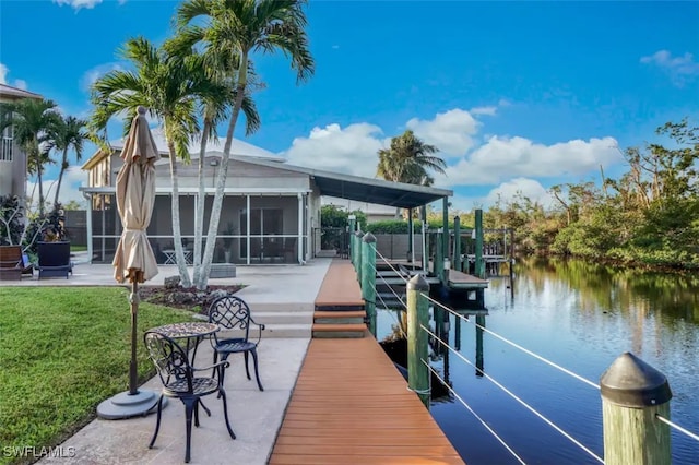 view of dock featuring a water view, a yard, and a patio area