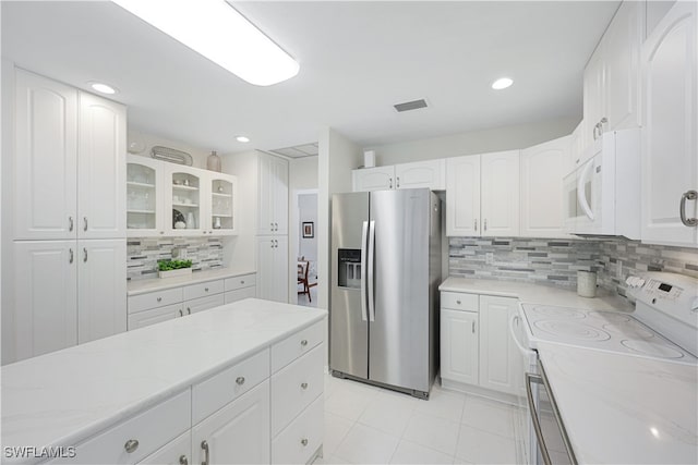 kitchen featuring decorative backsplash, white cabinetry, white appliances, and light tile patterned floors