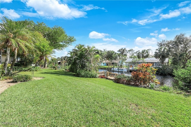 view of yard featuring a dock and a water view