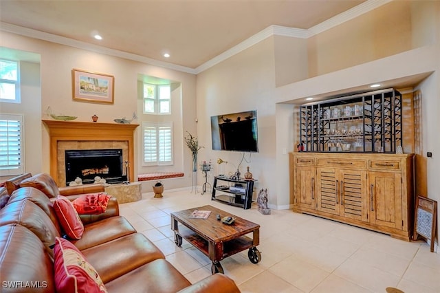 tiled living room featuring a towering ceiling, plenty of natural light, a high end fireplace, and crown molding