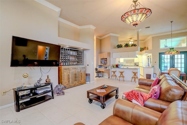 living room with ceiling fan with notable chandelier, ornamental molding, a towering ceiling, and french doors