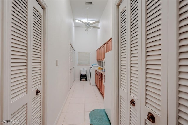 corridor with washer / clothes dryer and light tile patterned flooring