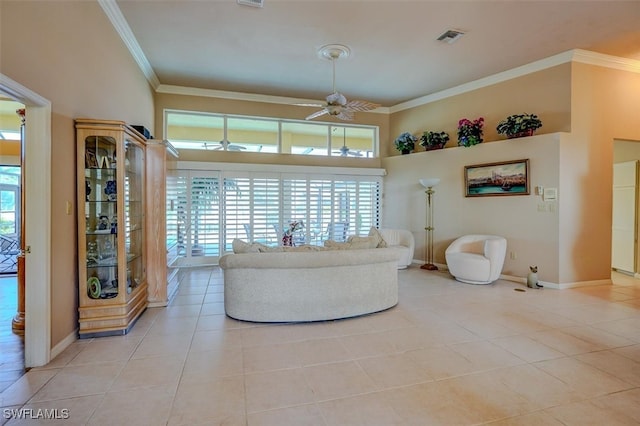 living room with a towering ceiling, ornamental molding, ceiling fan, and light tile patterned floors