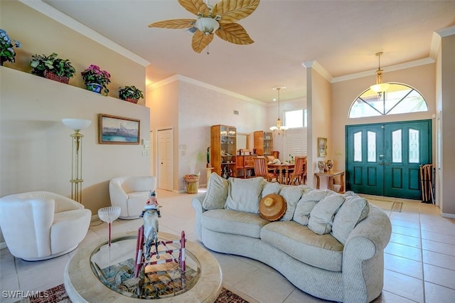 tiled living room with ceiling fan with notable chandelier and ornamental molding