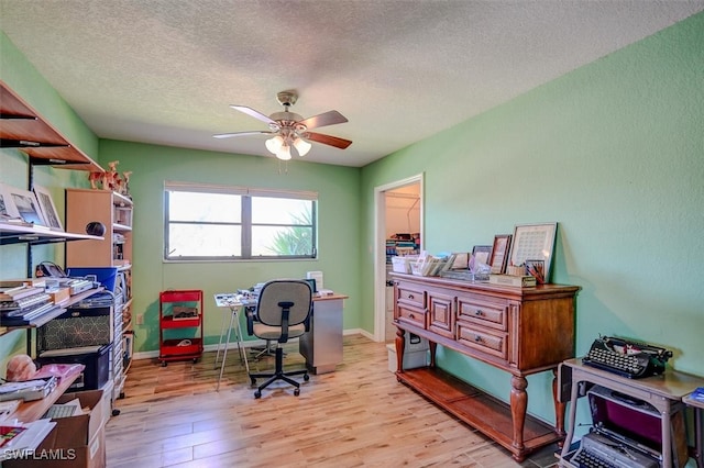 office featuring light hardwood / wood-style flooring, ceiling fan, and a textured ceiling