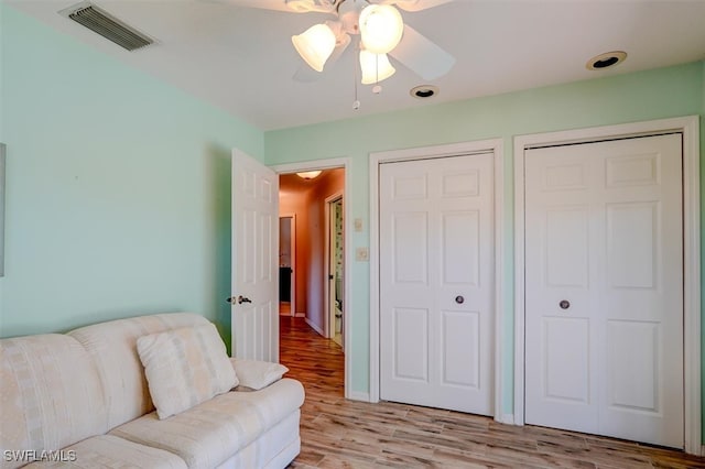 living room featuring light hardwood / wood-style floors and ceiling fan