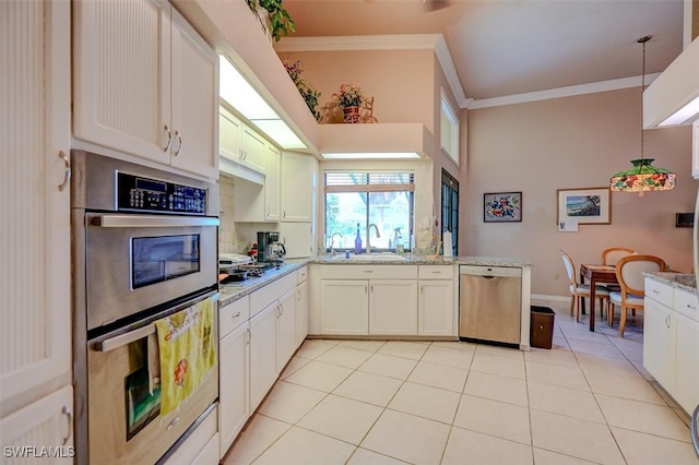 kitchen with appliances with stainless steel finishes, light stone countertops, light tile patterned floors, and decorative light fixtures