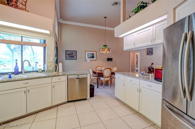 kitchen with appliances with stainless steel finishes, hanging light fixtures, light stone counters, crown molding, and sink