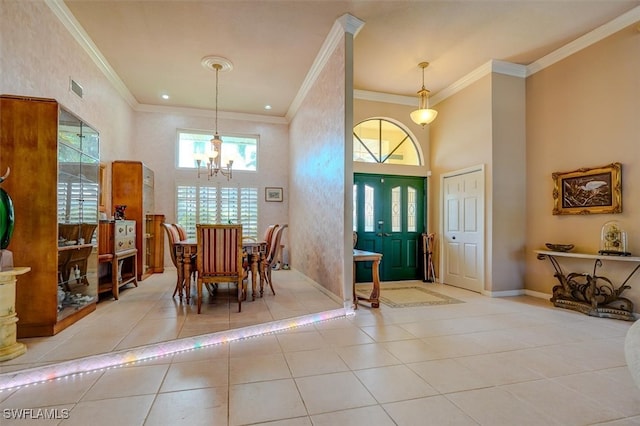 dining space with a high ceiling, ornamental molding, an inviting chandelier, and light tile patterned floors