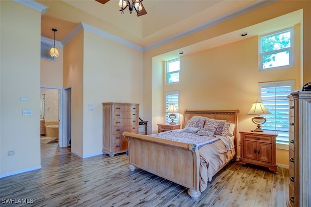 bedroom featuring light hardwood / wood-style flooring, a high ceiling, and multiple windows