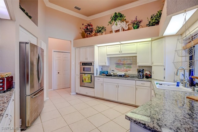 kitchen with light stone countertops, ornamental molding, sink, and stainless steel appliances