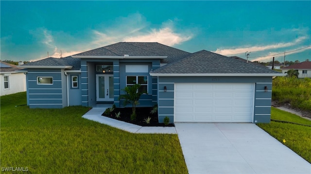 view of front of house with a garage and a yard