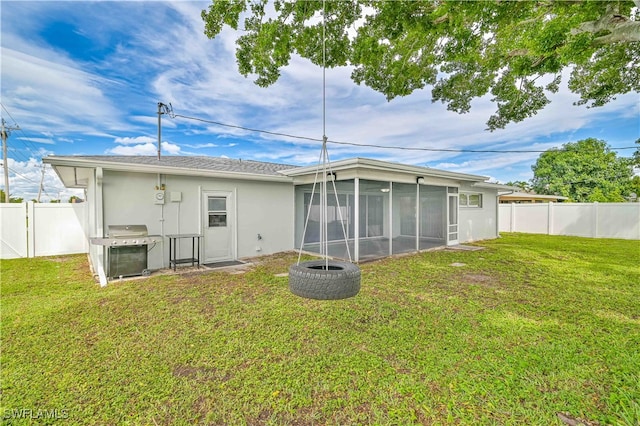 back of property featuring a sunroom and a yard