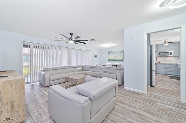 living room with ceiling fan and light hardwood / wood-style flooring