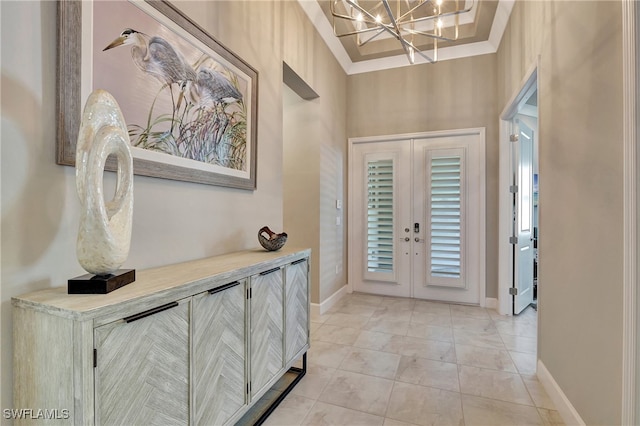 tiled entrance foyer featuring french doors, a notable chandelier, a towering ceiling, and ornamental molding