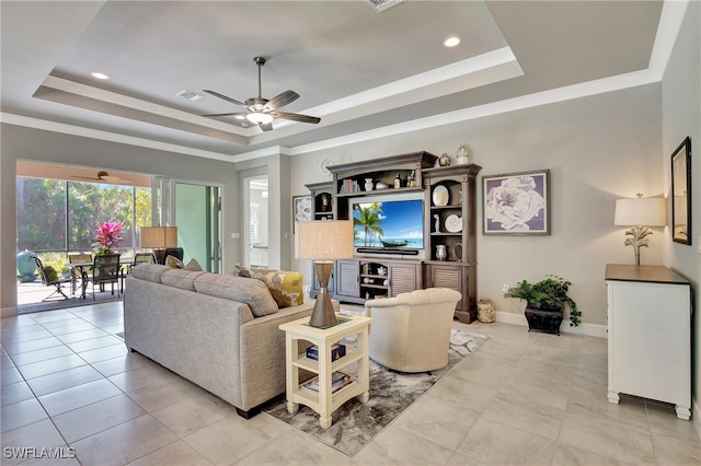 living room featuring ornamental molding, ceiling fan, and a raised ceiling