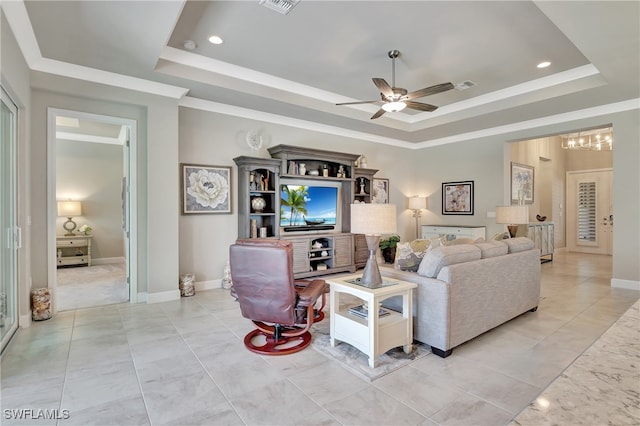 living room with ceiling fan and a raised ceiling