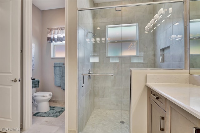 bathroom with vanity, toilet, and a shower with door