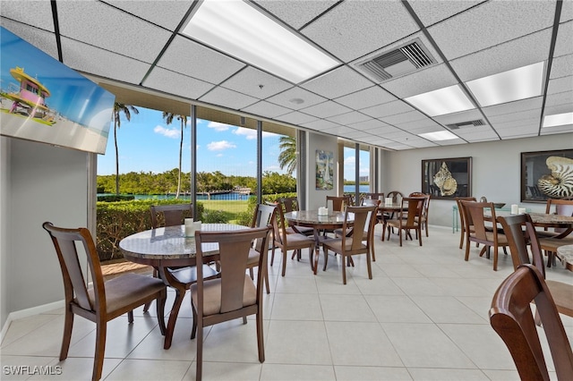 tiled dining room with a water view and a paneled ceiling