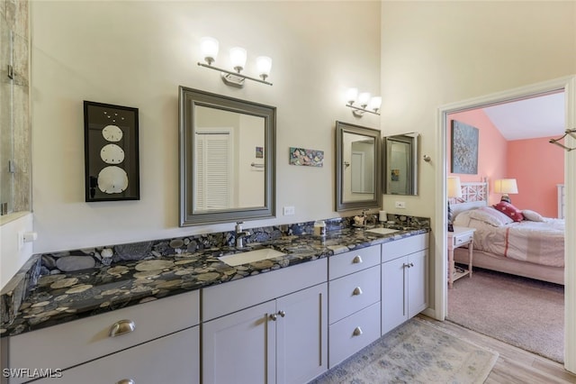 bathroom featuring hardwood / wood-style flooring, lofted ceiling, and vanity