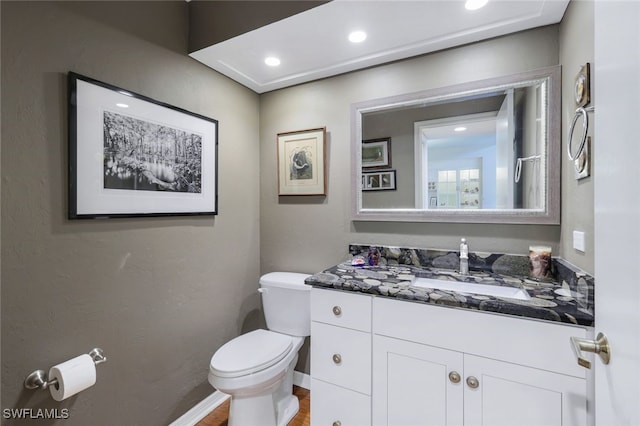 bathroom with vanity, hardwood / wood-style floors, and toilet