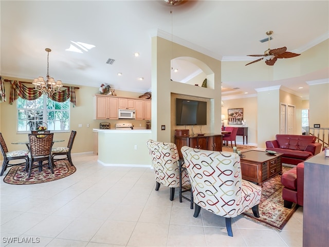 tiled living room featuring ceiling fan with notable chandelier, a towering ceiling, and crown molding