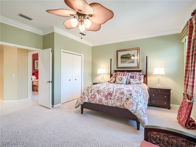 carpeted bedroom featuring ornamental molding, ceiling fan, and a closet