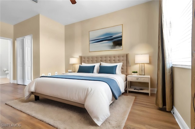 bedroom featuring connected bathroom, light hardwood / wood-style floors, and ceiling fan