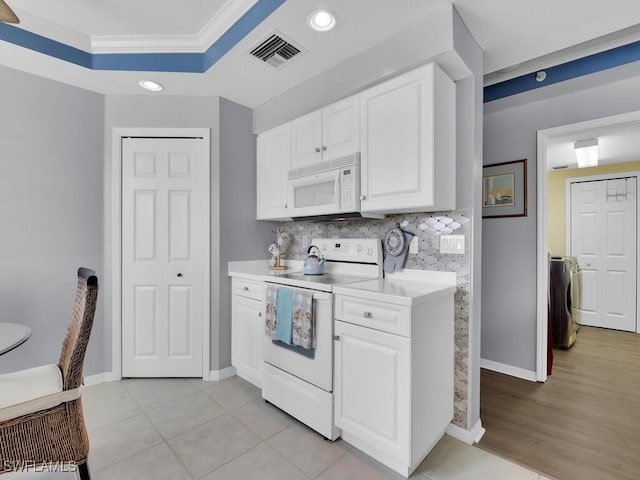 kitchen with white appliances, backsplash, white cabinetry, crown molding, and light hardwood / wood-style floors