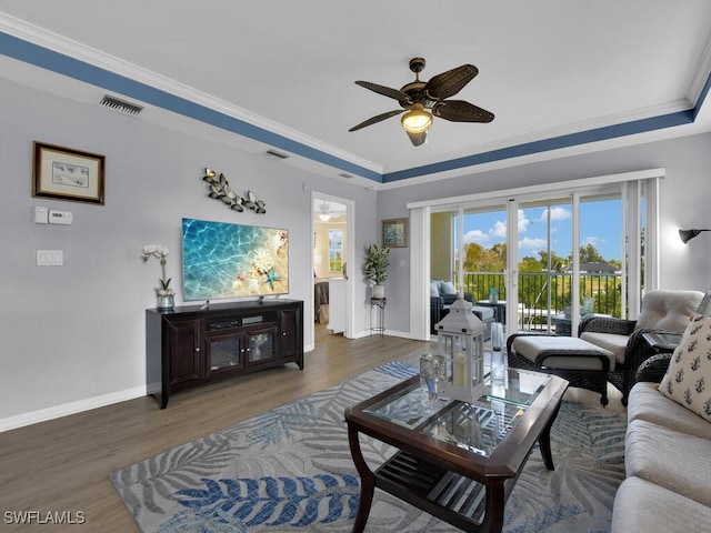 living room featuring ceiling fan, dark hardwood / wood-style floors, and crown molding