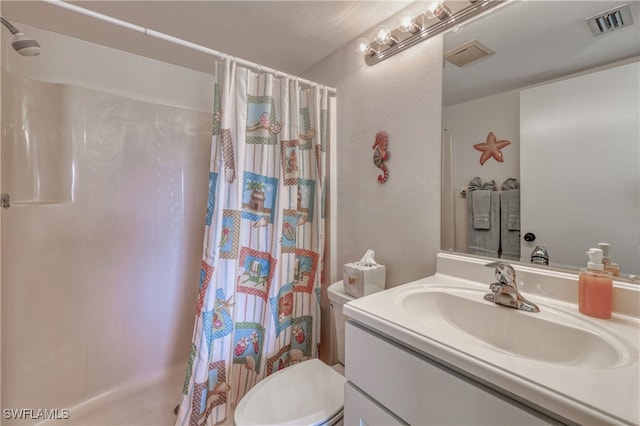 bathroom with curtained shower, vanity, and toilet