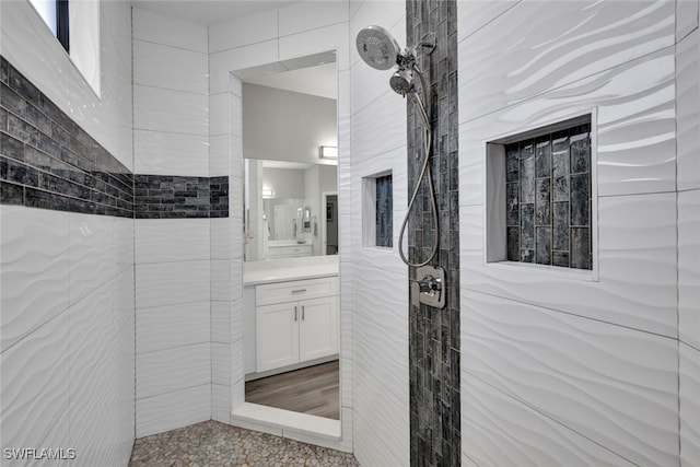 bathroom with vanity, hardwood / wood-style floors, and tiled shower