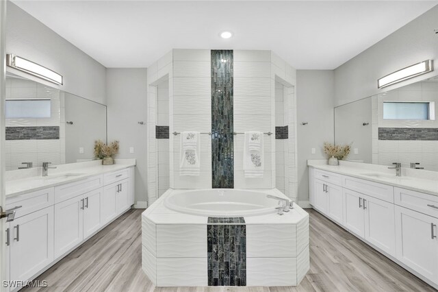 bathroom featuring vanity, wood-type flooring, and separate shower and tub