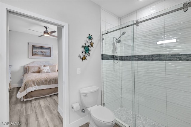 bathroom with toilet, walk in shower, hardwood / wood-style flooring, and ceiling fan