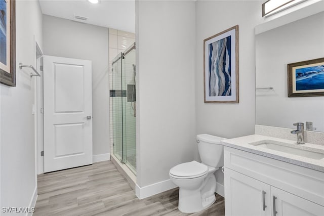 bathroom with vanity, wood-type flooring, toilet, and walk in shower