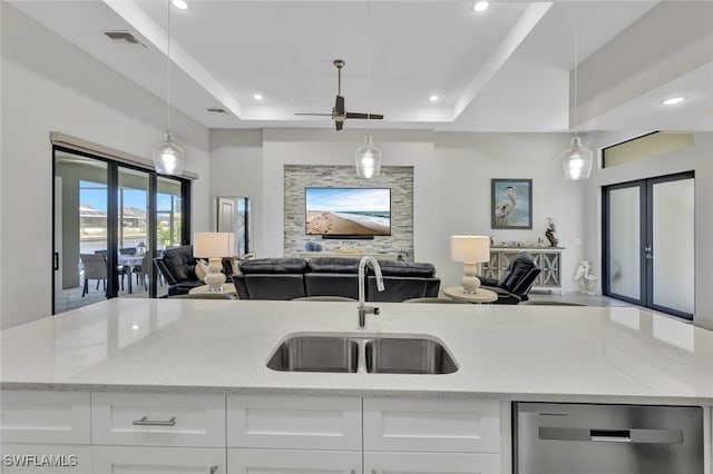 kitchen featuring white cabinets, a raised ceiling, dishwasher, french doors, and sink