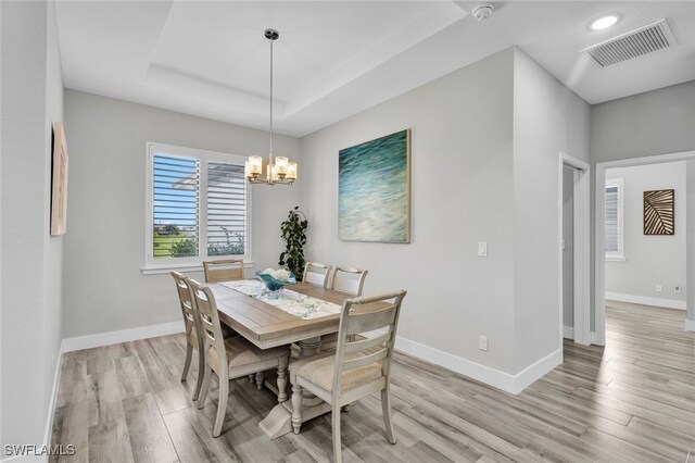 dining area featuring light hardwood / wood-style floors and an inviting chandelier