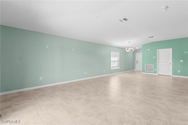 tiled empty room featuring a notable chandelier