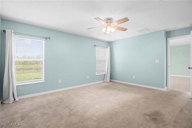 empty room with light colored carpet and ceiling fan