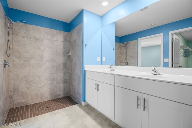 bathroom with vanity and a tile shower