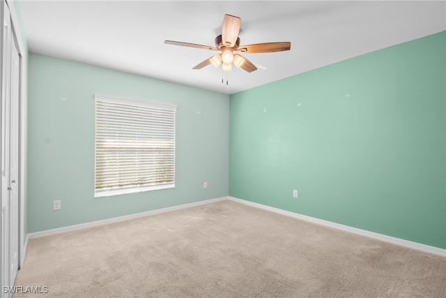 empty room featuring light colored carpet and ceiling fan