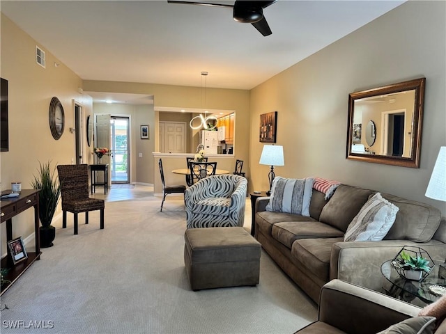 carpeted living room with ceiling fan